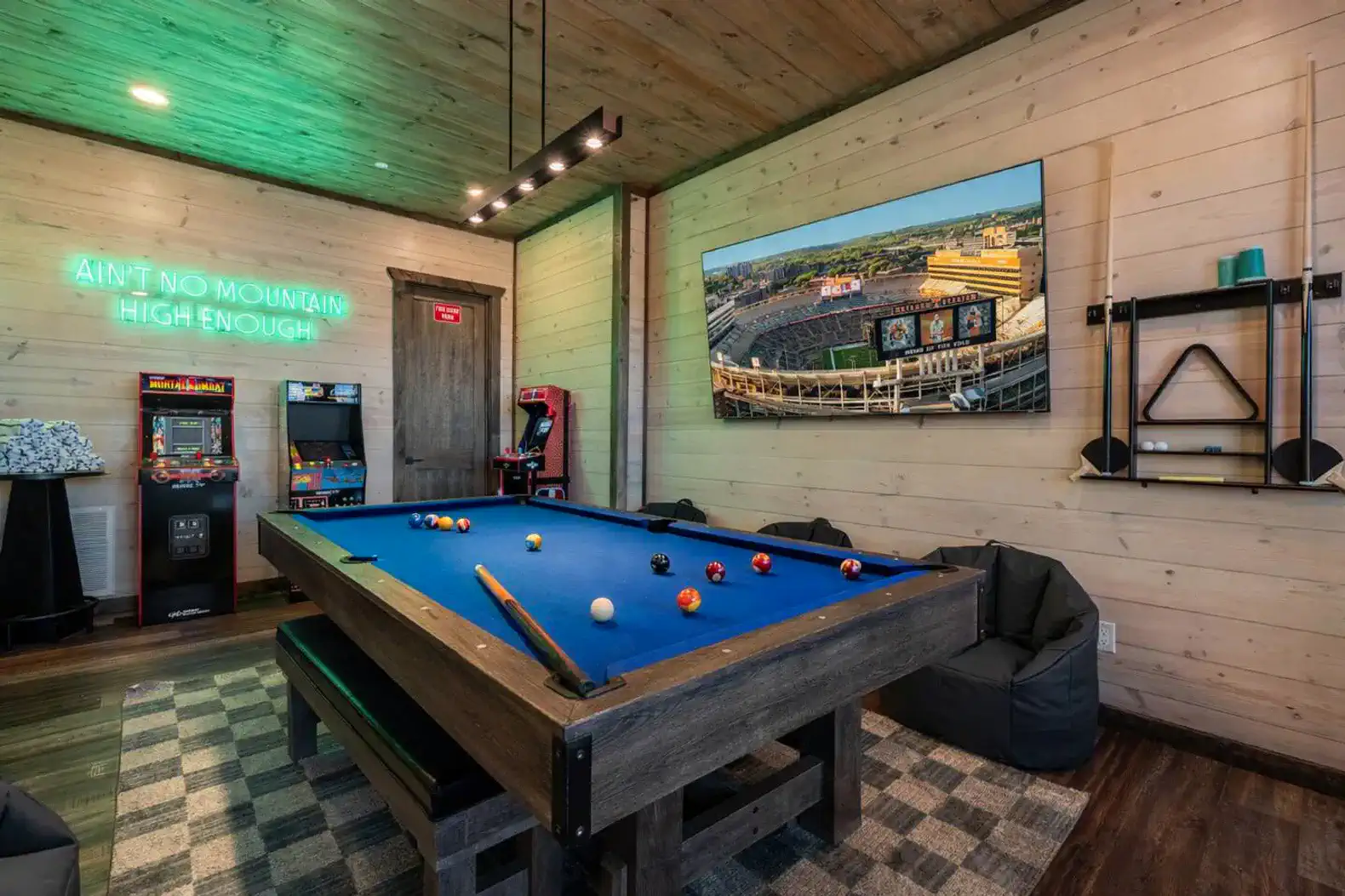 Game room with pool table, arcade games, and neon sign
