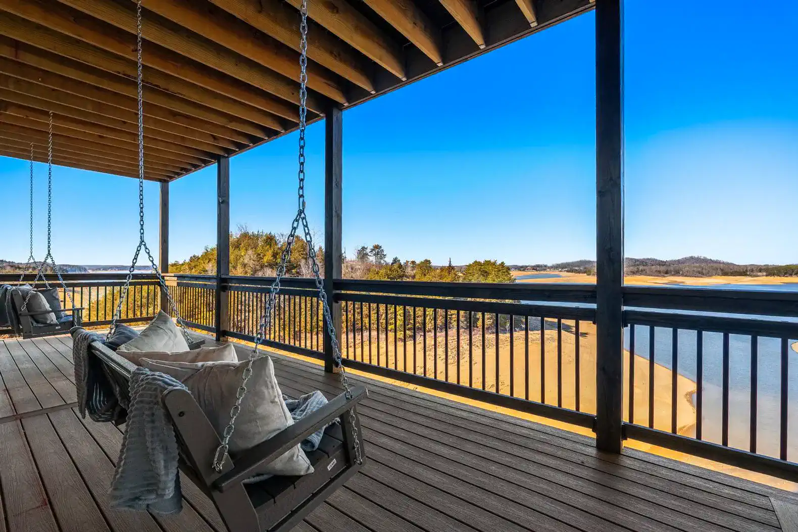 Spacious deck with swings overlooking the lake and surrounding landscape