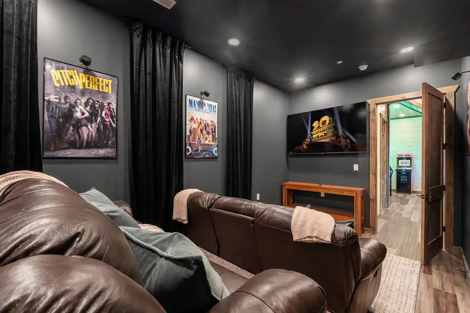 Cozy movie room with leather seating and wall posters